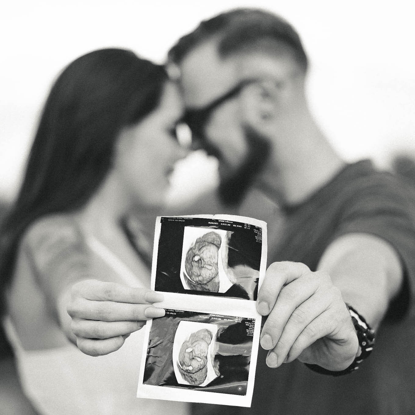 Couple holding ultrasound photos