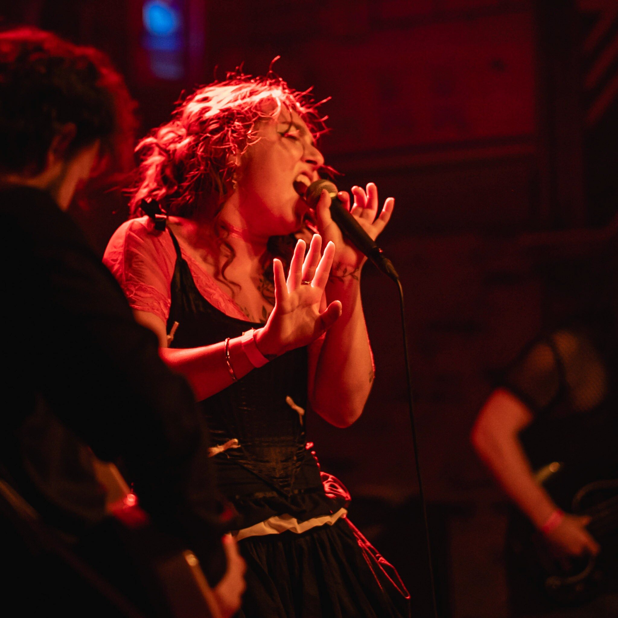 Singer performing under red stage light