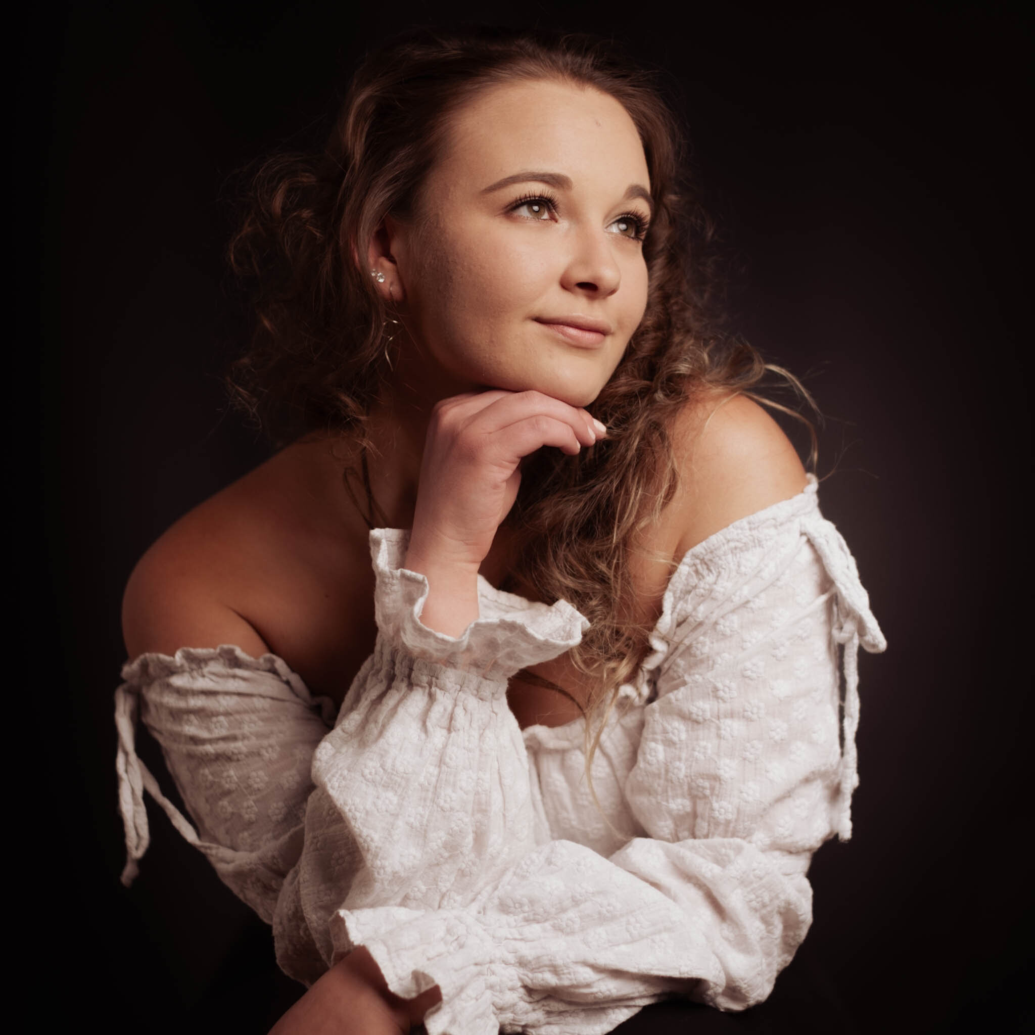 Portrait in white dress on dark background